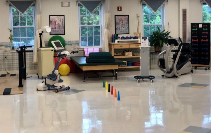A physical therapy room equipped with exercise machines and rehabilitation tools.