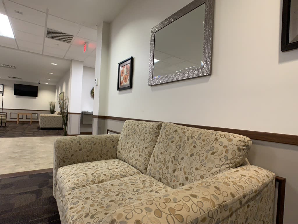A cozy waiting room with a patterned sofa and decorative elements.