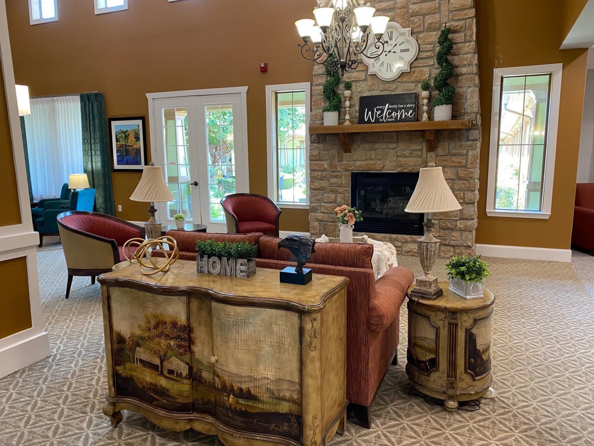 A cozy living room with elegant furnishings and a stone fireplace.