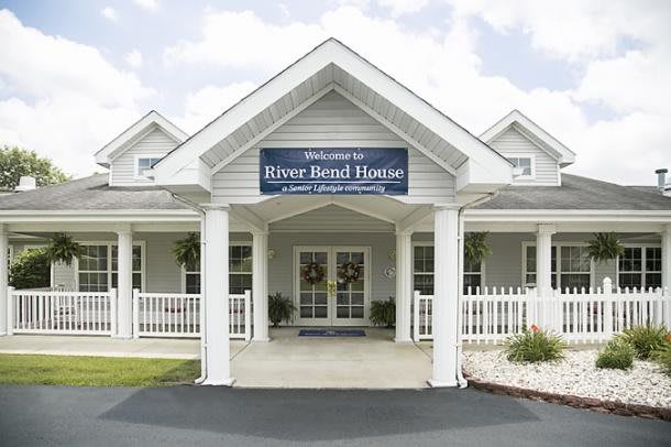 A welcoming front entrance of a house with a porch and sign.