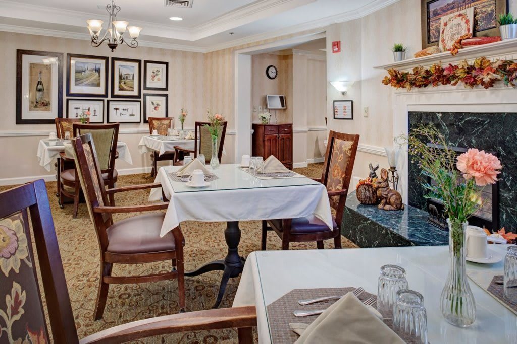 An elegant dining room with neatly arranged tables and chairs, adorned with tasteful decor and artwork on the walls.