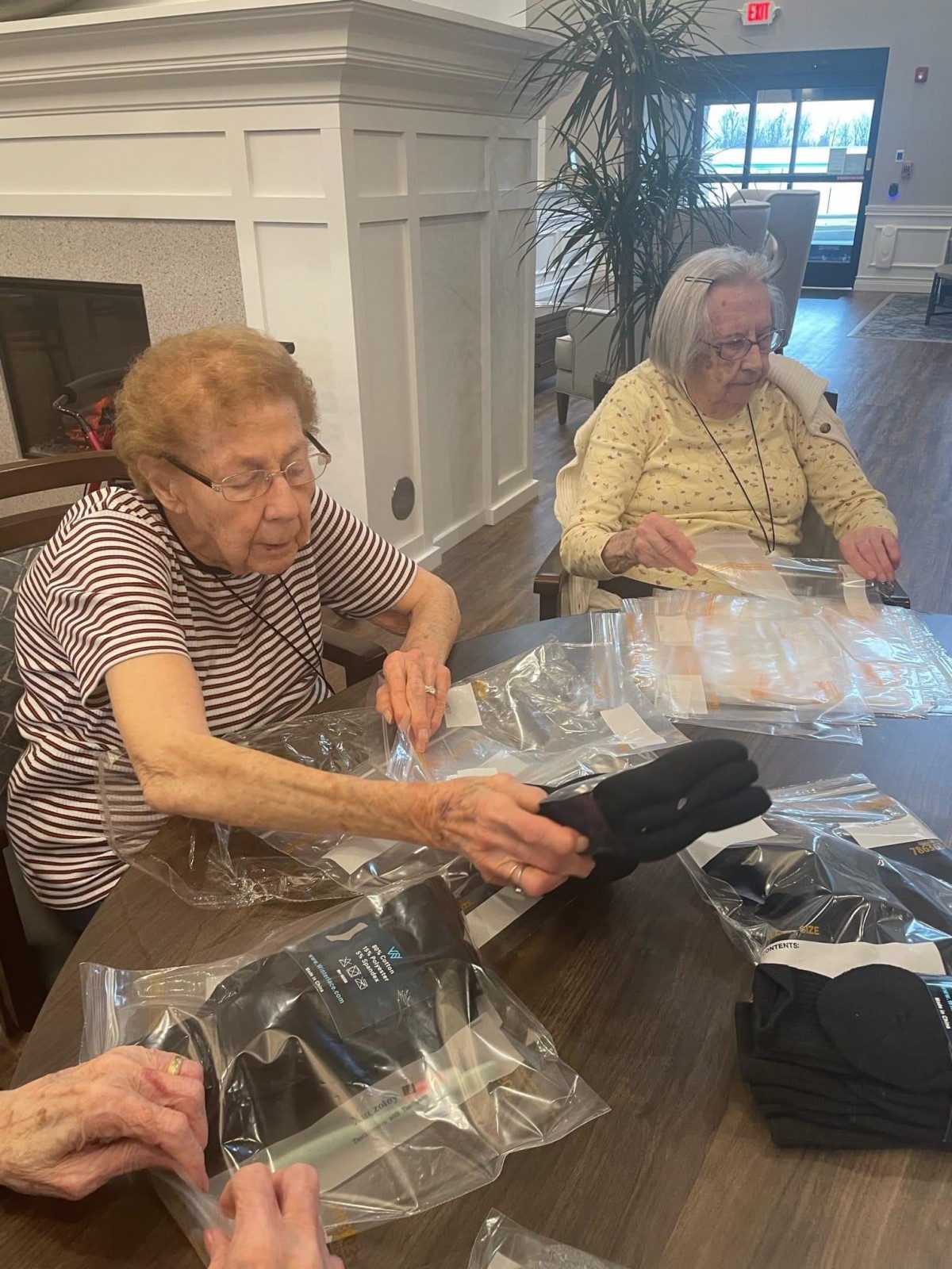Elderly women engaged in a community service activity, packing items together.