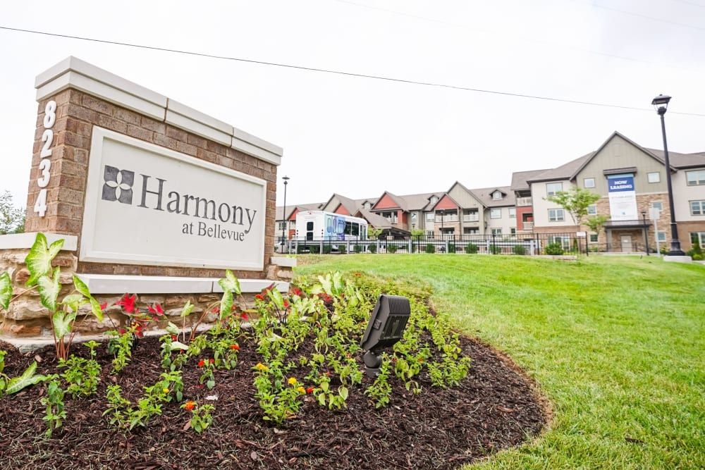 A landscaped area with a sign reading 'Harmony' in front of a residential building.