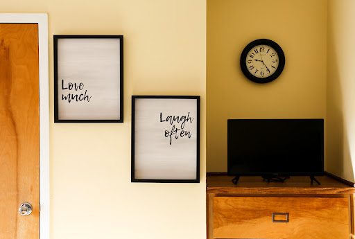 A cozy corner featuring inspirational wall art and a classic clock.