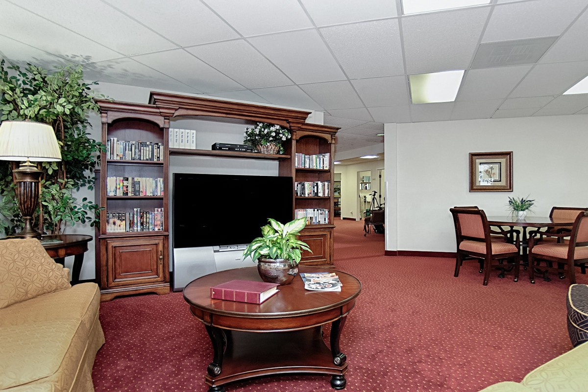 A cozy living room with classic furniture and a large television.