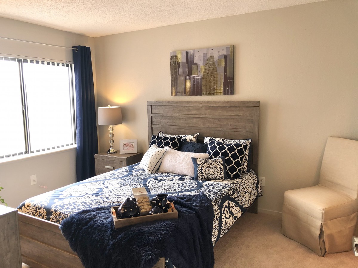 A cozy bedroom with a stylish bed, decorative pillows, and modern artwork.