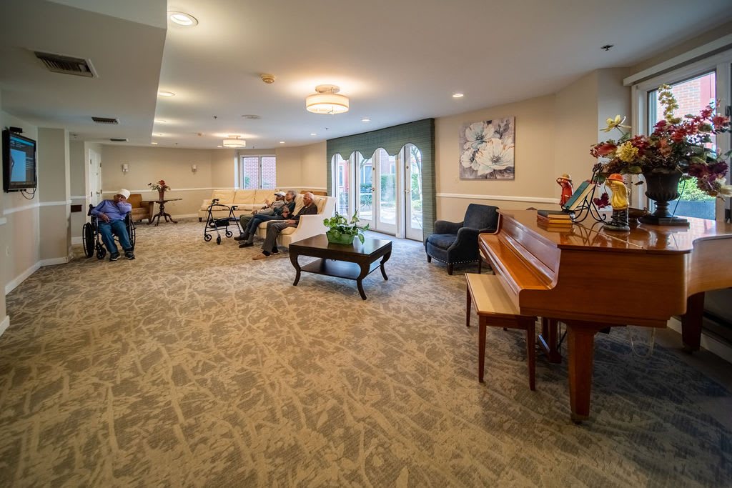 A spacious living room with multiple pianos and comfortable seating.