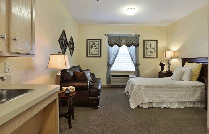 A cozy bedroom featuring a bed, sofa, and stylish decor.