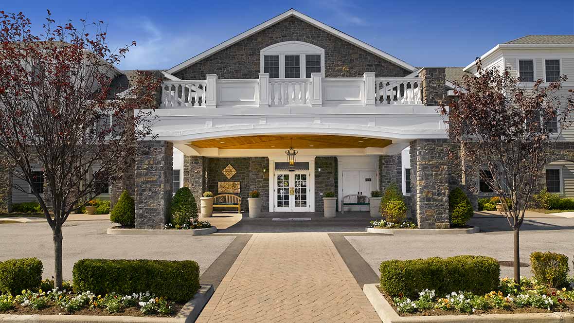 A beautiful stone facade house with a grand entrance and balcony.