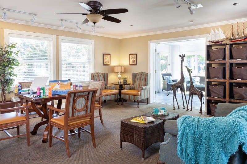 A cozy living room with ample natural light, featuring comfortable seating and elegant decor.