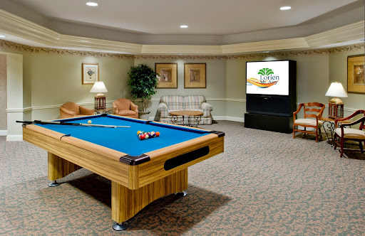 A cozy game room featuring a pool table, comfortable seating, and a television.