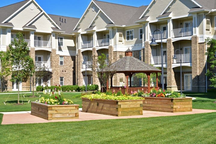 A residential apartment complex with a beautifully landscaped garden and gazebo.