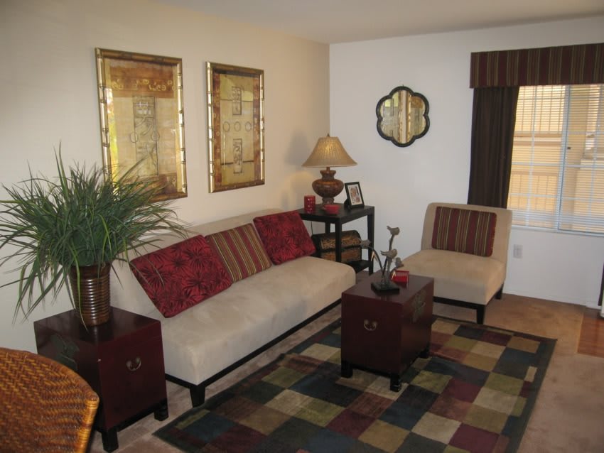 A cozy living room with a sofa and armchair, complemented by wall art and a decorative lamp.