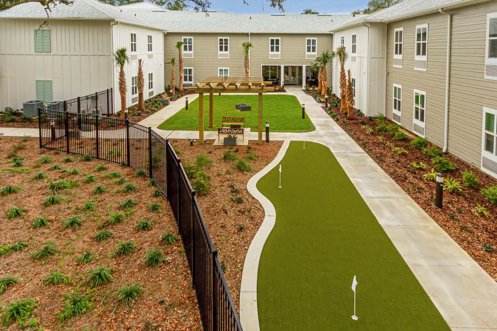 A courtyard featuring a landscaped garden with artificial turf and pathways, surrounded by residential buildings.