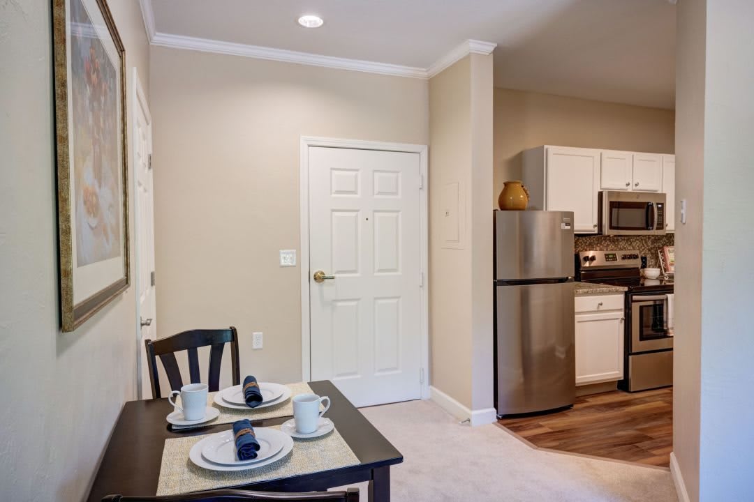 A modern kitchen and dining area featuring stainless steel appliances and a neatly set table.