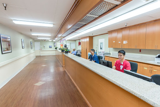 A view of the reception area in a hospital, featuring staff members attending to patients.