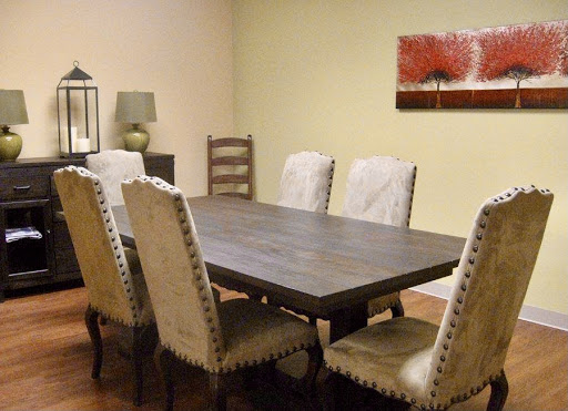A cozy dining room featuring a wooden table surrounded by elegant chairs, complemented by tasteful artwork on the wall.