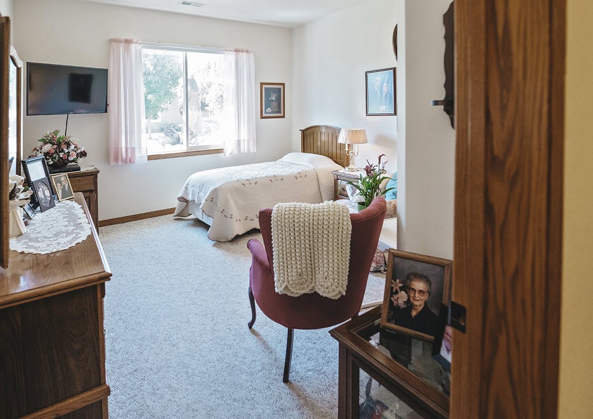 A cozy, well-decorated bedroom with a large window and comfortable furnishings.