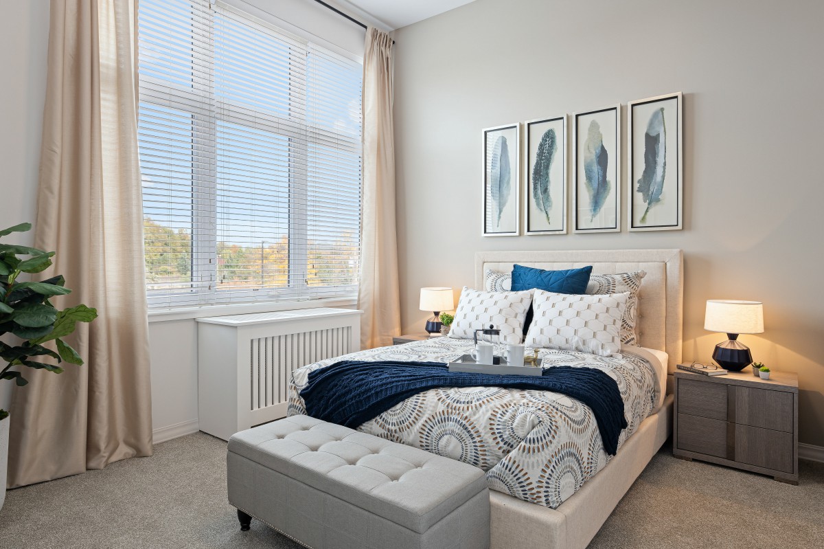 A cozy and elegantly decorated bedroom with large windows and stylish artwork.