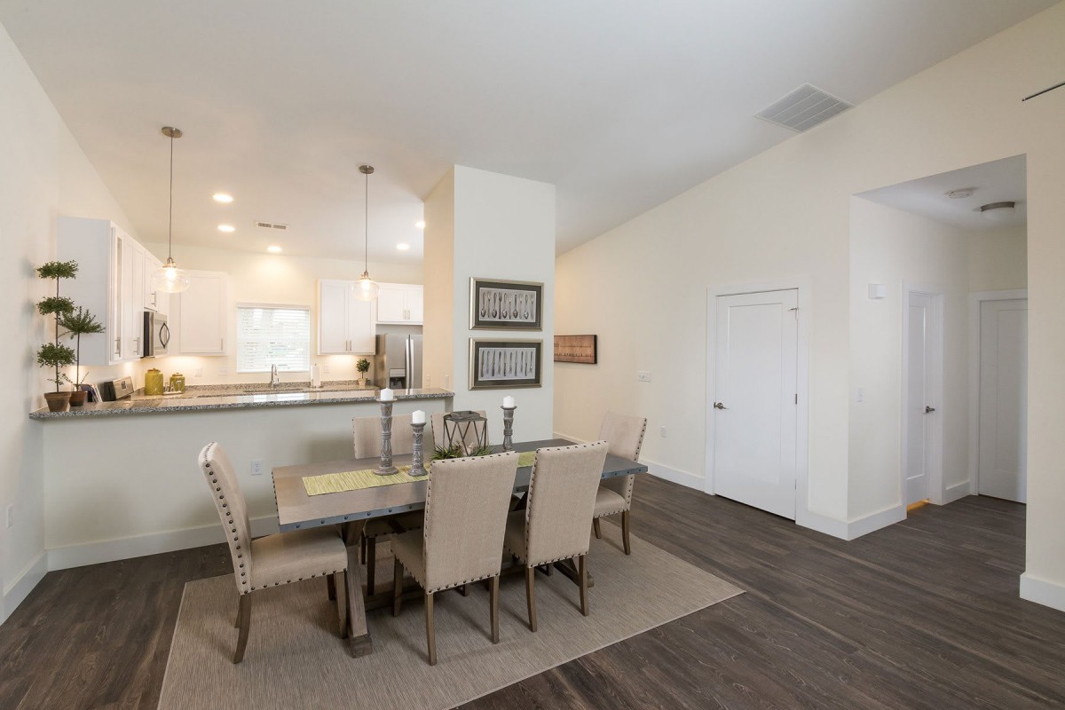Modern dining area with an open concept kitchen and neutral decor.