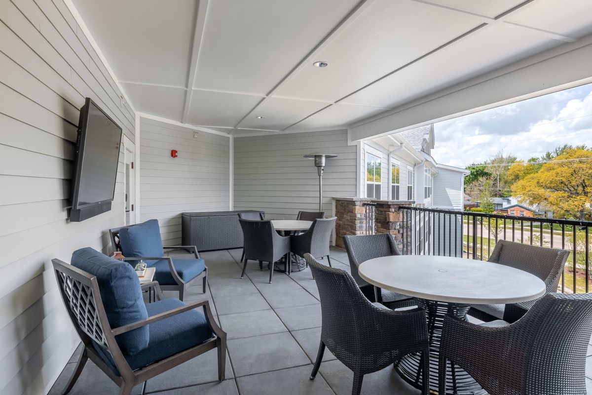 A modern covered patio with outdoor seating and tables.