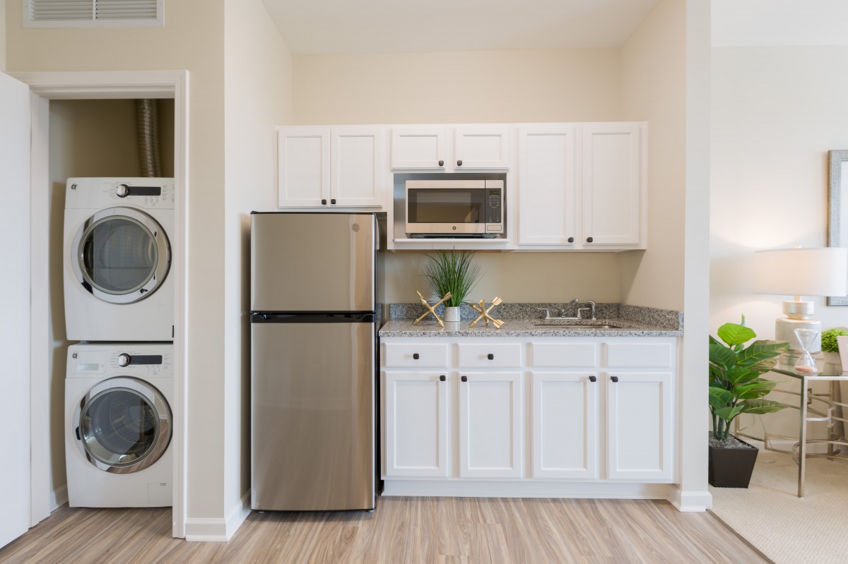 A modern kitchen with stainless steel appliances and white cabinetry.