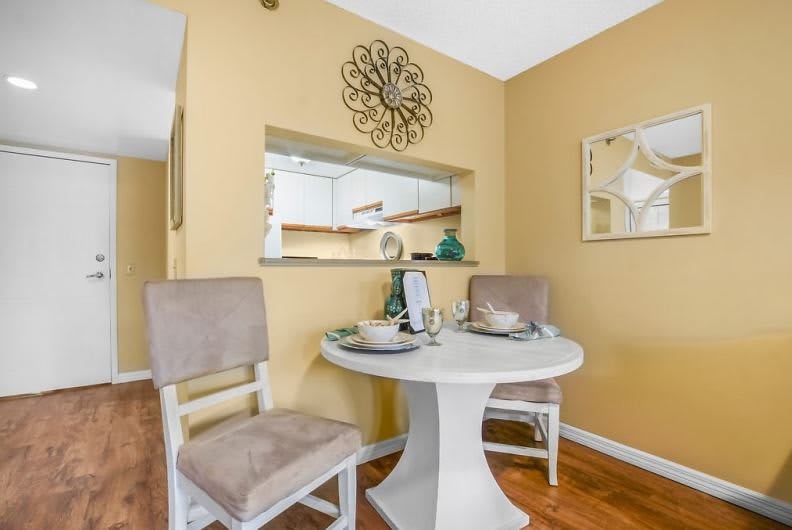 A cozy dining area with a round table, two chairs, and stylish wall decor.