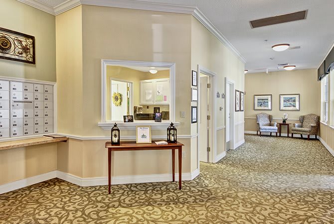 A traditional styled hallway with decorative carpeting and furniture.