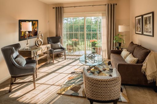 A modern and bright living room with large windows allowing natural sunlight to illuminate the space, featuring stylish furniture and home decor.