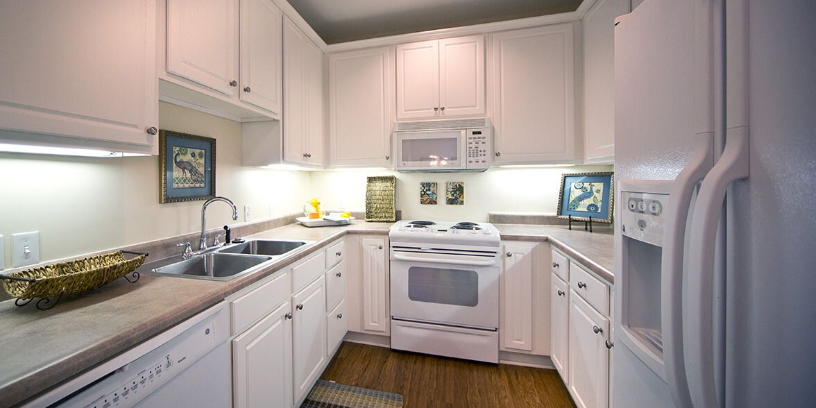 Modern kitchen with white cabinets and appliances.
