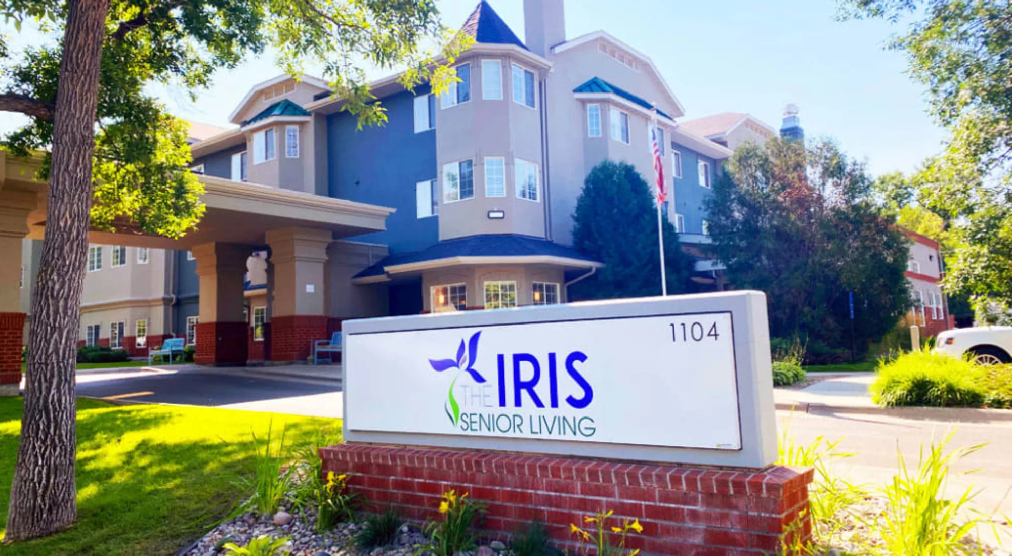 Exterior view of Iris Senior Living with a prominent sign in the foreground.