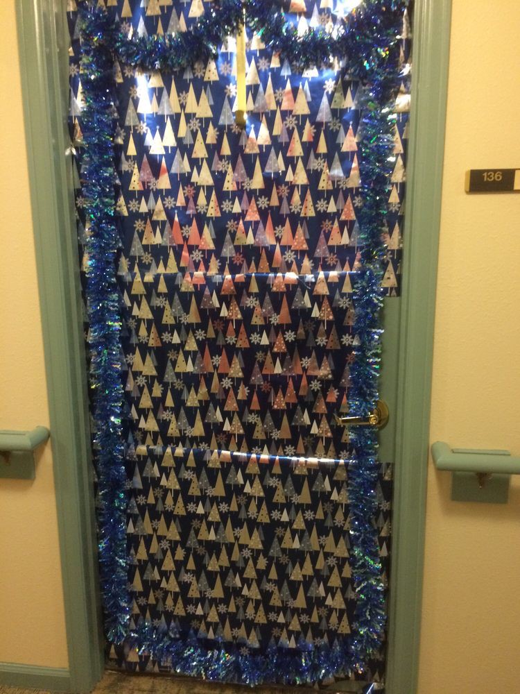 A door decorated with strings of colorful paper cranes and blue tinsel for a festive appearance.