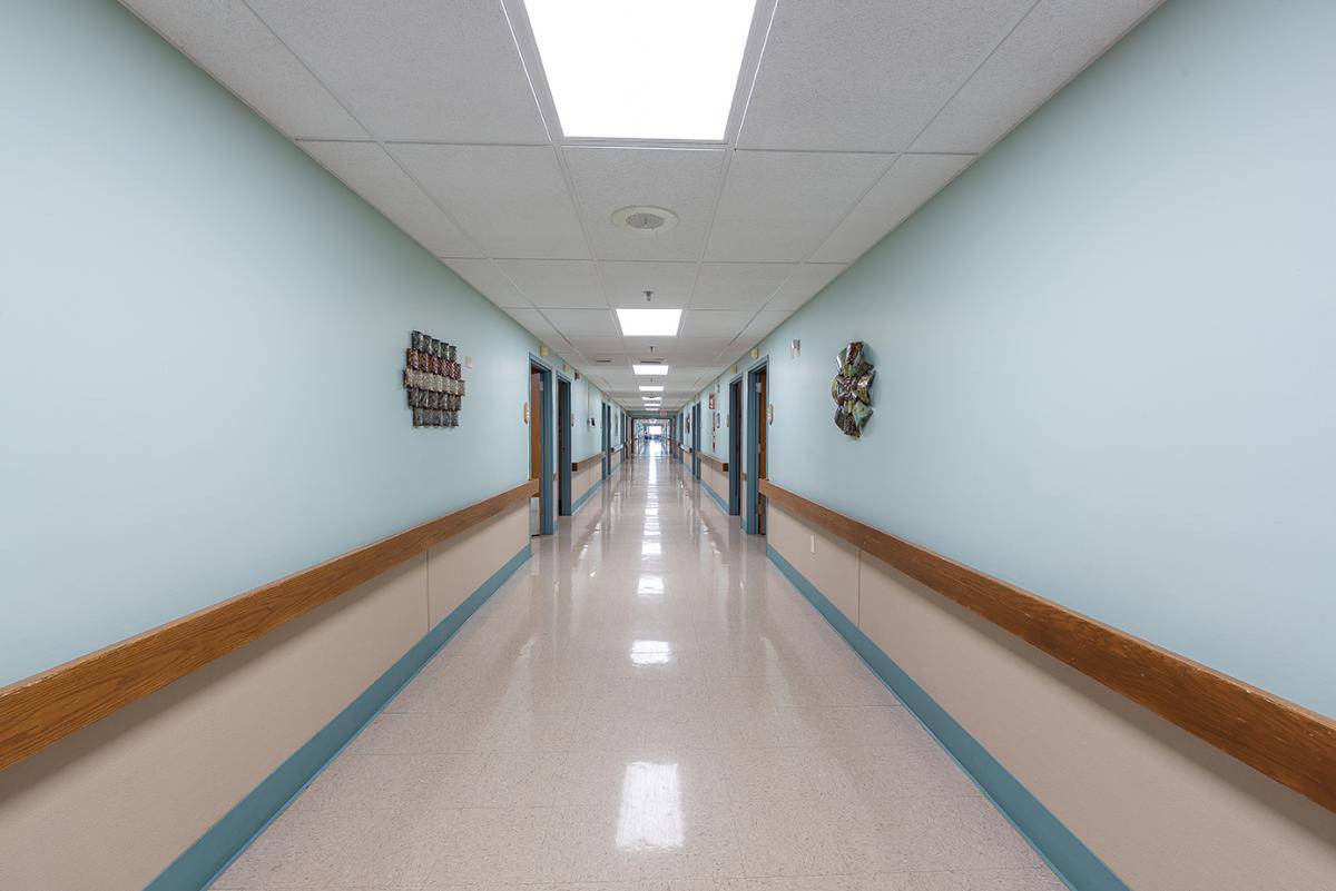 A long, bright hallway in a hospital setting.