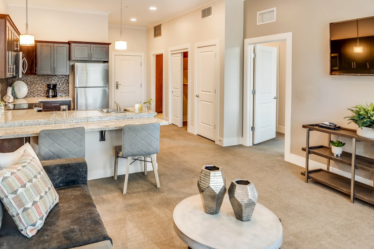 Modern apartment interior with an open floor plan featuring a kitchen and living area.