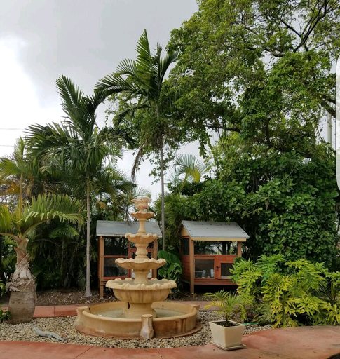 A serene garden featuring a beautiful fountain surrounded by lush greenery.