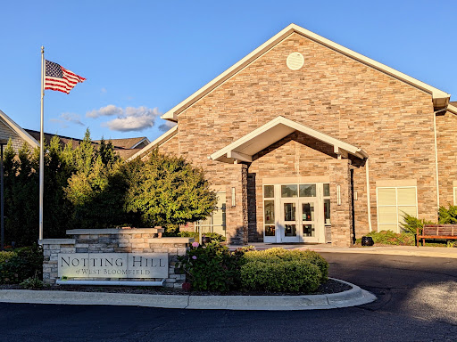 A welcoming view of a brick building with a flag, bathed in warm sunlight.
