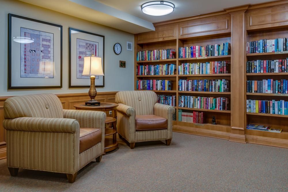 A cozy reading area with armchairs and a bookshelf filled with books.