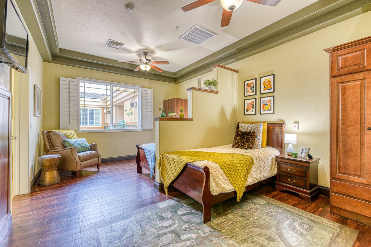 A cozy bedroom with a single bed, wooden flooring, and elegant decor.