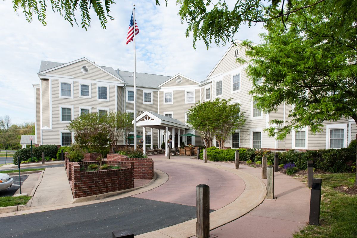 A large residential building with a pathway and flag in front.