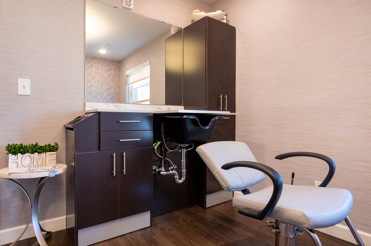 Interior of a modern beauty salon with a styling chair and sink.