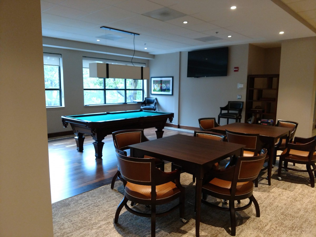 A cozy billiards room with a pool table and seating area.