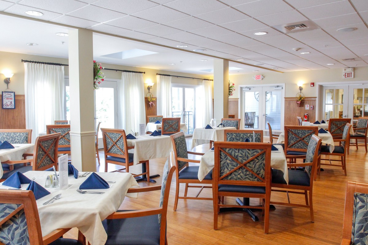 An elegant dining area with neatly set tables and chairs, featuring a bright and welcoming atmosphere.