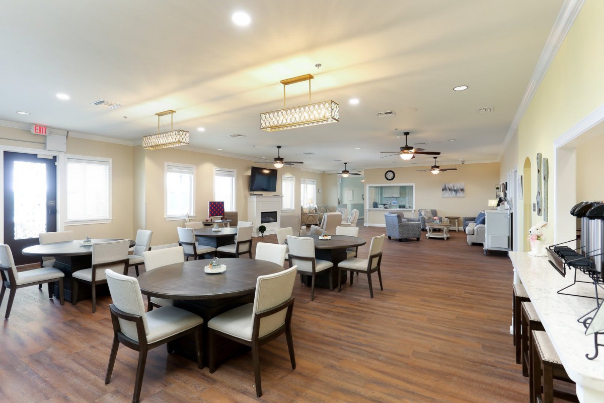 A spacious and well-lit dining area with modern furniture and wooden flooring.