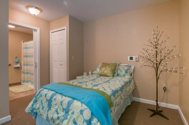 A cozy bedroom with a single bed adorned with colorful bedding.