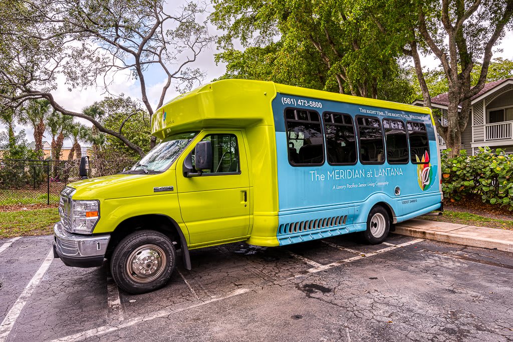 A colorful shuttle bus parked in a scenic outdoor area with trees around.