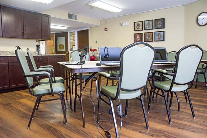 A conference room with a large table and multiple chairs arranged for a meeting.