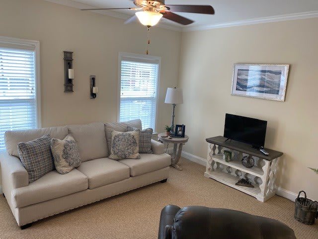 A cozy living room with a sofa, coffee table, and television.