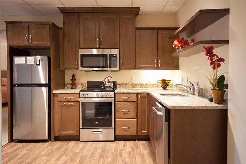 A modern kitchen with wooden cabinets and stainless steel appliances.
