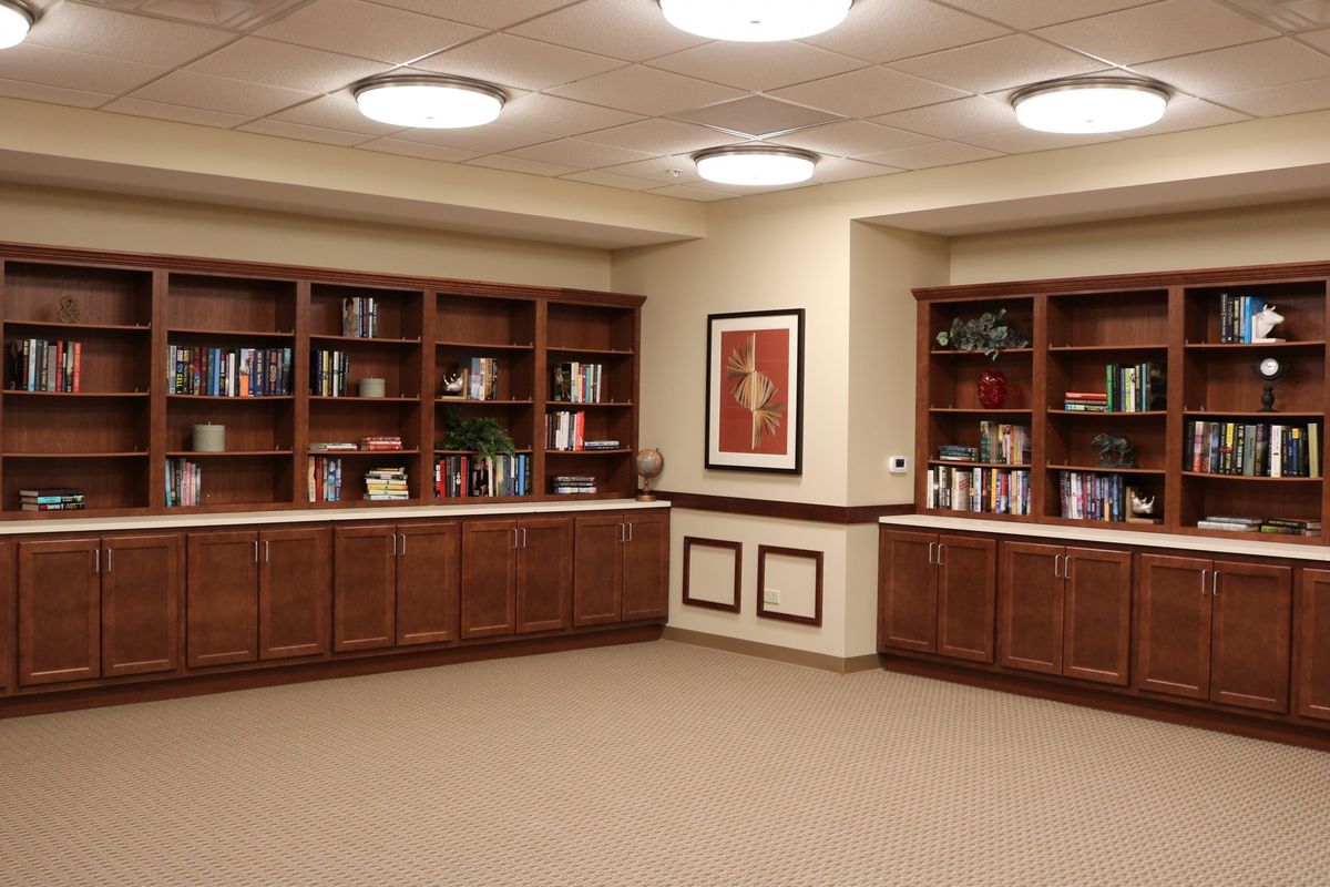 A quiet library space with wooden bookshelves and artwork on the wall.