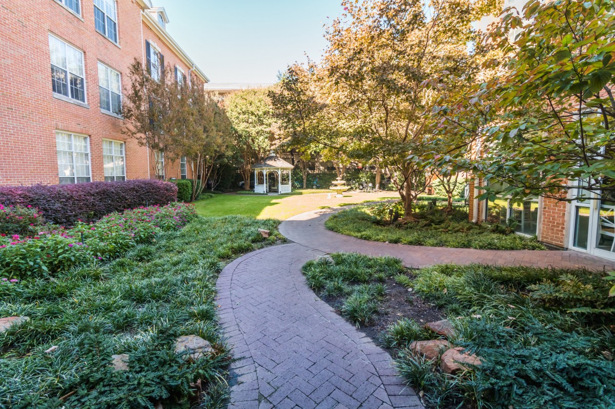 A winding pathway through a landscaped garden area next to a building.
